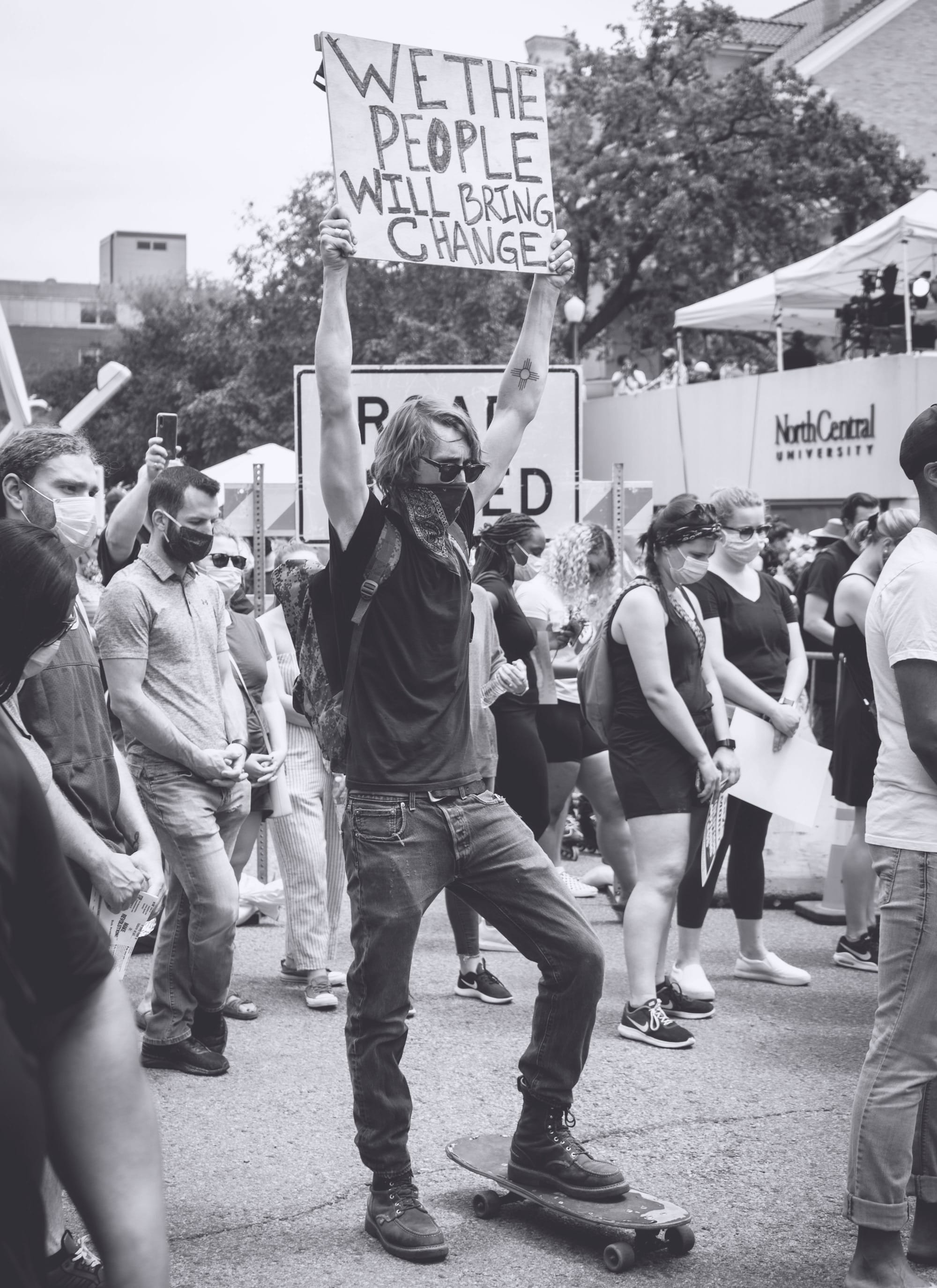 people holding white and black banner during daytime