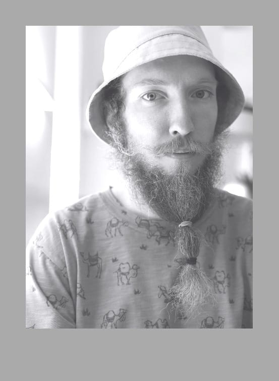 man in crew neck shirt wearing hat and a beard with hairbands