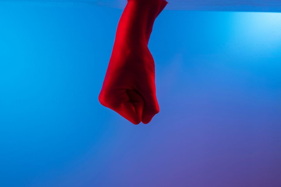 Blue gradient with fist in water tank; fist is lit up bright red.