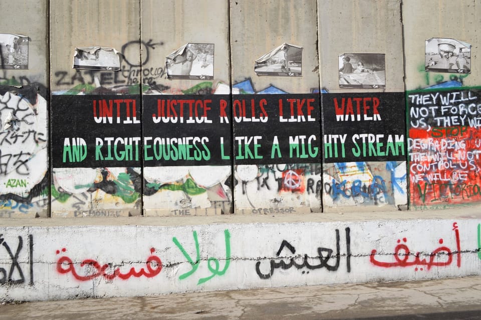 Writing on the Israel/Palestine separation wall with graffiti